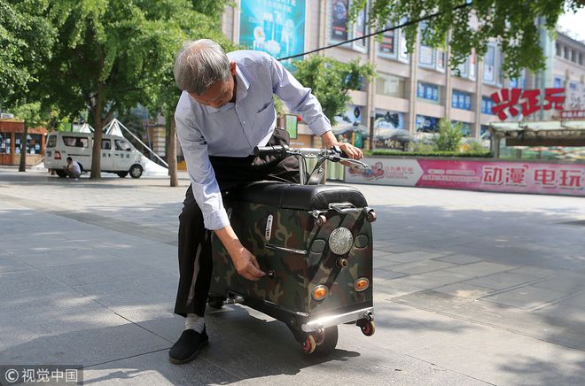 72岁老人纯手工打造拉杆箱乐鱼(中国)体育电动车 骑车上路飞驰引市民围观(图3)